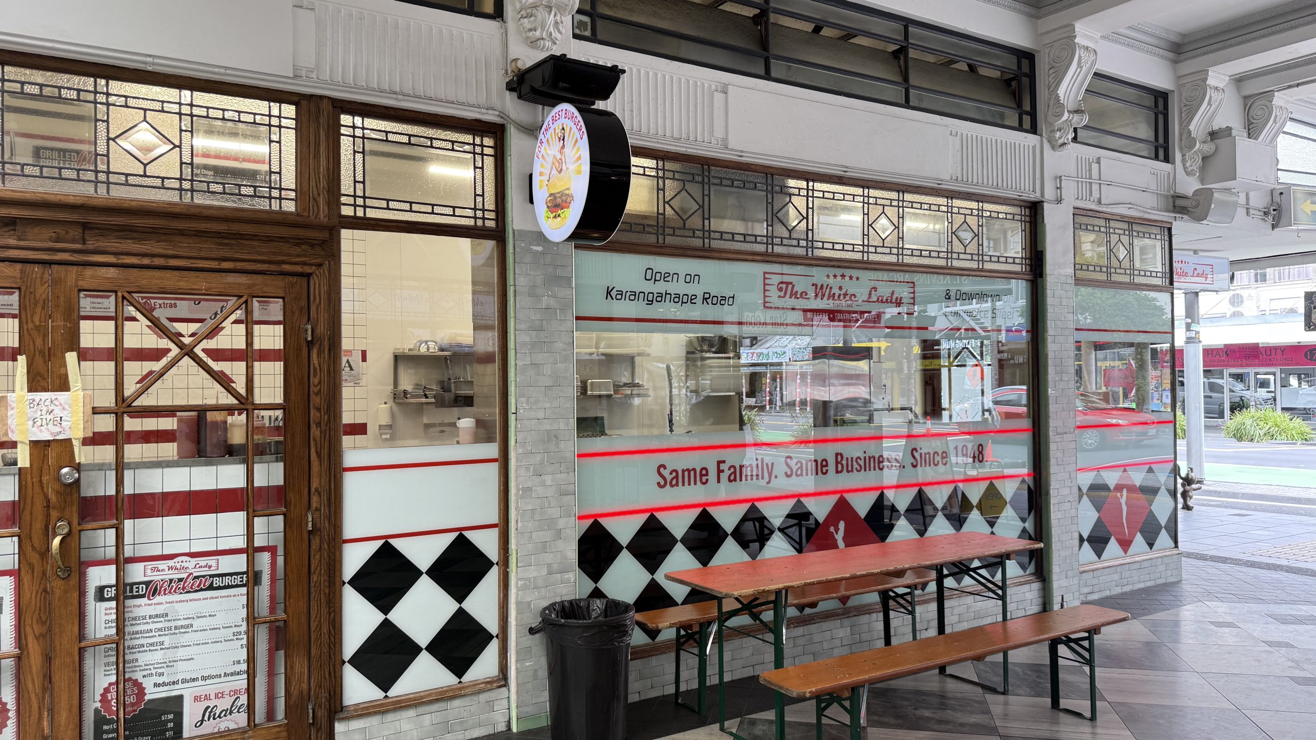 Close up of The White Lady double cheeseburger stacked high with juicy beef patties melted cheese and classic Kiwi toppings.